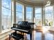 Sun-filled room showcasing a grand piano with views of the surrounding landscape at 32602 Archdale, Chapel Hill, NC 27517