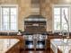 Close up of kitchen featuring Wolf range, stainless steel hood, and dual windows at 32602 Archdale, Chapel Hill, NC 27517