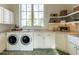 Bright laundry room with front loading washer and dryer, stone flooring, and ample storage at 32602 Archdale, Chapel Hill, NC 27517