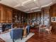 Expansive library with wood bookcases, hardwood floors, fireplace and multiple seating and desk areas at 32602 Archdale, Chapel Hill, NC 27517
