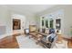 Cozy living room with hardwood floors, comfortable seating, and large windows offering views of the well-manicured yard at 32602 Archdale, Chapel Hill, NC 27517