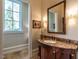 Elegant powder room features a custom vanity, stylish mirror, and decorative lighting at 32602 Archdale, Chapel Hill, NC 27517