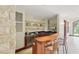 Stylish wet bar with stone accents, wine fridge, and comfortable seating for entertaining at 32602 Archdale, Chapel Hill, NC 27517