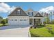Charming two-story home boasts a manicured lawn, a two car garage, and welcoming stone accents on the porch at 35 Hewitt Wds Dr, Clayton, NC 27527