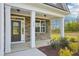 Covered porch with stone accents and white columns, leads to an inviting front door at 35 Hewitt Wds Dr, Clayton, NC 27527