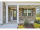 Covered porch with stone accents and white columns, leads to an inviting front door at 35 Hewitt Wds Dr, Clayton, NC 27527