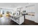 Modern kitchen with white cabinetry, granite countertops, and a dining area with large windows at 435 Rowe Way, Knightdale, NC 27545