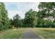 Picturesque walking path lined with lush greenery and mature trees at 4801 Gossamer Ln # 105, Raleigh, NC 27616