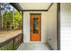 Orange front door with sidelights and porch at 4860 Fayetteville Rd, Durham, NC 27713