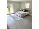 Light-filled bedroom with french doors, gray wood floors, and a decorative area rug at 5088 Christian Light Rd, Fuquay Varina, NC 27526