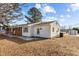 The back exterior of the home, with access door, small deck, and white vinyl siding at 5088 Christian Light Rd, Fuquay Varina, NC 27526
