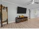 Living room featuring hardwood floors and a large TV at 5088 Christian Light Rd, Fuquay Varina, NC 27526