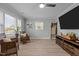 Living area with hardwood floors, two armchairs, and a large TV at 5088 Christian Light Rd, Fuquay Varina, NC 27526