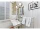 Charming bathroom with pedestal sink, ornate mirror, and white wood paneling at 517 N East St, Raleigh, NC 27604