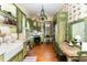 Rustic kitchen with green cabinets, white sink, and decorative wallpaper at 517 N East St, Raleigh, NC 27604