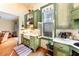 Charming kitchen featuring green cabinets, farmhouse sink, and unique wallpaper at 517 N East St, Raleigh, NC 27604