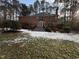 Brick house with large deck and partially snow covered yard at 704 Misty Isle Pl, Raleigh, NC 27615