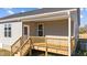 A covered back porch featuring wooden railings and stairs, offering outdoor relaxation at 75 Brookhaven Dr, Spring Hope, NC 27882