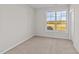 A bright, carpeted bedroom with a large window providing natural light at 75 Brookhaven Dr, Spring Hope, NC 27882