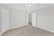 A bedroom with soft carpet featuring two doors, neutral paint, and plenty of sunlight at 8 Looping Horse Cir, Angier, NC 27501