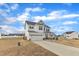 Side view of a white two-story home featuring a two car garage, covered porch and concrete driveway at 8 Looping Horse Cir, Angier, NC 27501
