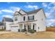 Angle view of white two-story home with covered porch, stone-base columns and concrete driveway at 8 Looping Horse Cir, Angier, NC 27501