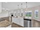 Kitchen island featuring a farmhouse sink, granite countertops, and stainless dishwasher at 8 Looping Horse Cir, Angier, NC 27501
