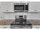 Close-up of stainless steel appliances, granite countertops, and white subway tile at 8 Looping Horse Cir, Angier, NC 27501