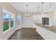 An open-concept kitchen and dining area features wood floors and a picturesque window view at 8 Looping Horse Cir, Angier, NC 27501