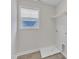 Bright laundry room featuring tiled floor, white walls, window, washer and dryer hookups, and wire shelving at 8 Looping Horse Cir, Angier, NC 27501