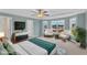 Bright primary bedroom featuring a ceiling fan, a cozy seating area, and large windows, offering natural light at 8 Looping Horse Cir, Angier, NC 27501