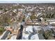 Winter aerial view of a quiet, snow-covered neighborhood with houses, mature trees and a street with cars parked along it at 819 Cumberland St, Raleigh, NC 27610