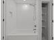 Bright bathroom featuring a tiled tub/shower and storage shelves in a renovated space at 819 Cumberland St, Raleigh, NC 27610