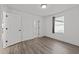 Bedroom with wood-look flooring, white walls, a window with blinds, and a doorway at 819 Cumberland St, Raleigh, NC 27610