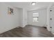 Simple bedroom featuring wood-look flooring, white walls, a small window, and a door at 819 Cumberland St, Raleigh, NC 27610