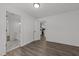 Bedroom with wood-look flooring, white walls, and doorways to the kitchen and bathroom at 819 Cumberland St, Raleigh, NC 27610