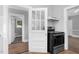 Kitchen with a door, black stove, tile backsplash, and wood floors at 945 Sycamore St, Rocky Mount, NC 27801