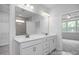 Double vanity bathroom with a large mirror and a view of another room at 91 Priming Way, Angier, NC 27501