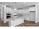 Modern kitchen with white cabinets, granite island, and stainless steel appliances at 91 Priming Way, Angier, NC 27501