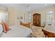 Sunlit bedroom boasts an antique armoire, neutral decor, and comfortable seating area by bright shuttered windows at 101 Bonica Creek Dr, Garner, NC 27529