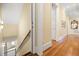 Elegant hallway featuring hardwood floors, white trim, and a staircase leading to lower level at 101 Bonica Creek Dr, Garner, NC 27529