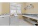 Functional laundry room with built-in shelving, modern washer/dryer, and counter space at 101 Bonica Creek Dr, Garner, NC 27529