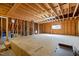Large unfinished room with exposed wooden beams, subflooring, and a bright window at 101 Bonica Creek Dr, Garner, NC 27529