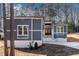 Gray house with stone accents, a long driveway, and surrounding trees at 110 Mohave Dr, Louisburg, NC 27549