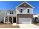 Charming two-story home featuring a two-car garage, and a mix of brick and neutral siding at 148 Babbling Brook Dr, Clayton, NC 27520