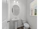 Small bathroom with pedestal sink, toilet, and oval mirror at 148 Babbling Brook Dr, Clayton, NC 27520