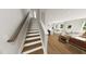 The hardwood stairs case leads up to an open concept room with a kitchen, living, and dinning area at 290 Beacon Dr, Pittsboro, NC 27312