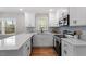 Bright kitchen featuring white cabinets, stainless steel appliances, light backsplash, and quartz countertops at 3305 Victor Pl, Raleigh, NC 27604