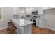 Well-lit kitchen with white cabinets, stainless steel appliances, quartz countertops, and barstool seating at 3305 Victor Pl, Raleigh, NC 27604