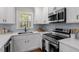 Well-lit kitchen with white cabinets, stainless steel appliances, and quartz countertops at 3305 Victor Pl, Raleigh, NC 27604